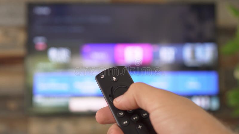 Mano masculina sujeta el mando a distancia de la tv y cambia los canales de tv