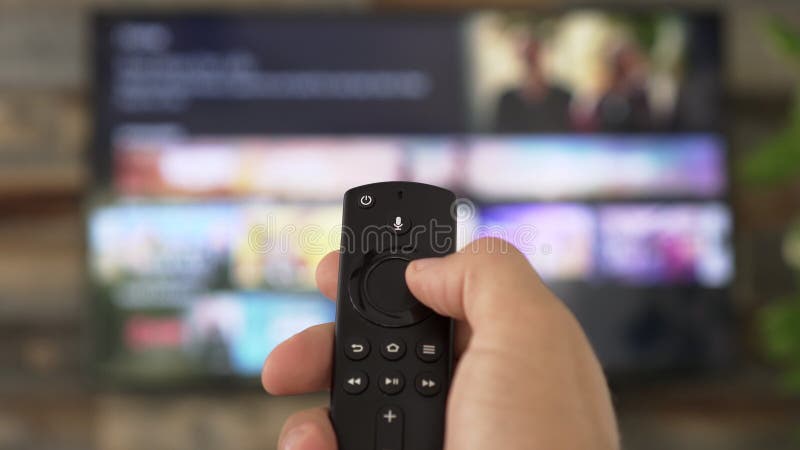 Mano masculina sujeta el mando a distancia de la tv y cambia los canales de tv