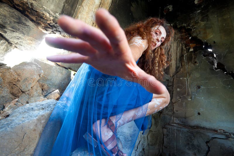 Woman with white body henna in abandoned building, reaching down to the camera. Woman with white body henna in abandoned building, reaching down to the camera