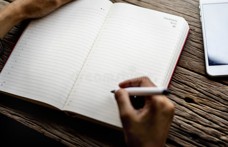 Mano que detiene a Pen Write Diary Notebook