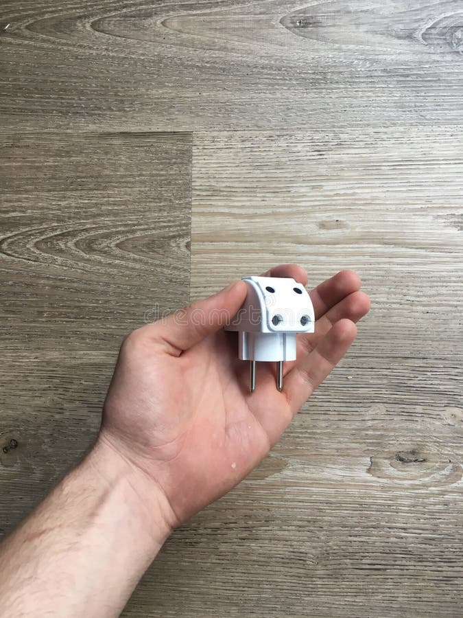 Mano que lleva a cabo un multiplug blanco fotografía de archivo libre de regalías Mano que lleva a cabo un multiplug blanco fotografía de archivo libre de regalías