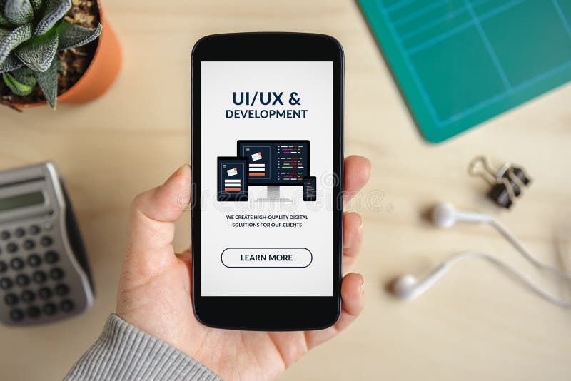 Mano que sostiene el teléfono elegante con diseño de UI/UX y concepto del desarrollo en la pantalla foto de archivo libre de regalías