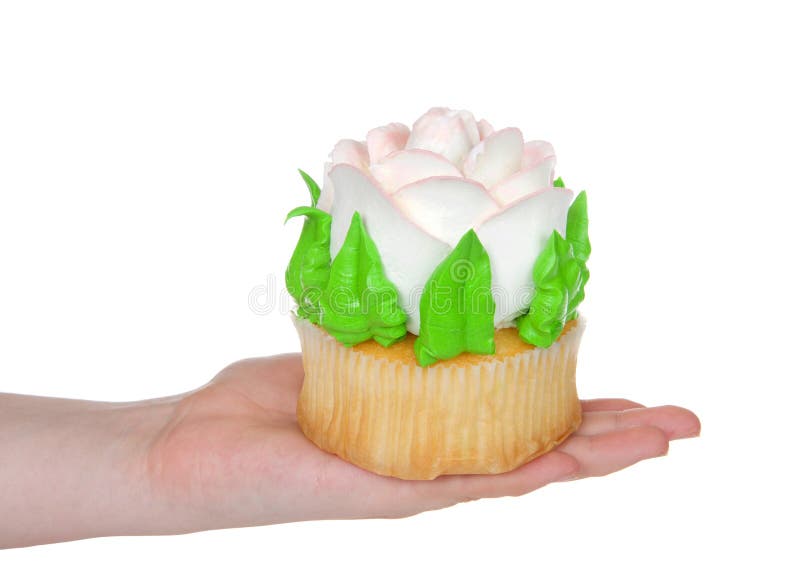 Mano que sostiene la torta color de rosa helada grande de la taza aislada en blanco fotografía de archivo Mano que sostiene la torta color de rosa helada grande de la taza aislada en blanco fotografía de archivo