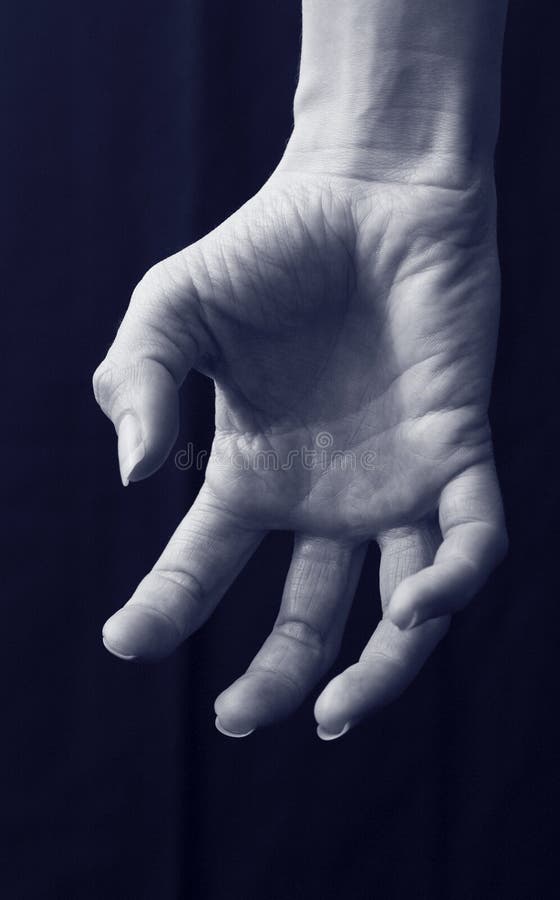 Close up of female scary grabbing hand with curled fingers under blue moon light isolated on black background. Close up of female scary grabbing hand with curled fingers under blue moon light isolated on black background