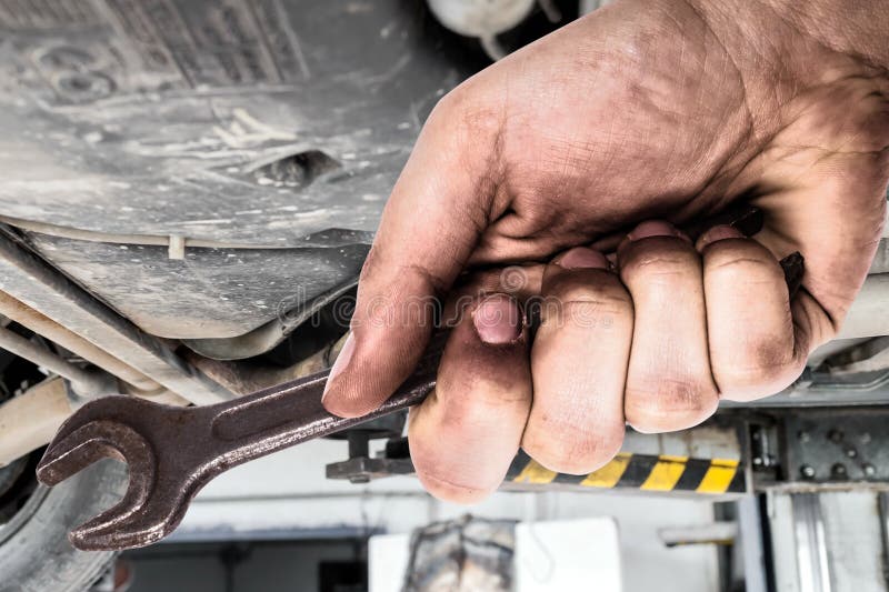 Mano sucia que sostiene la llave Servis del coche foto de archivo Mano sucia que sostiene la llave Servis del coche foto de archivo