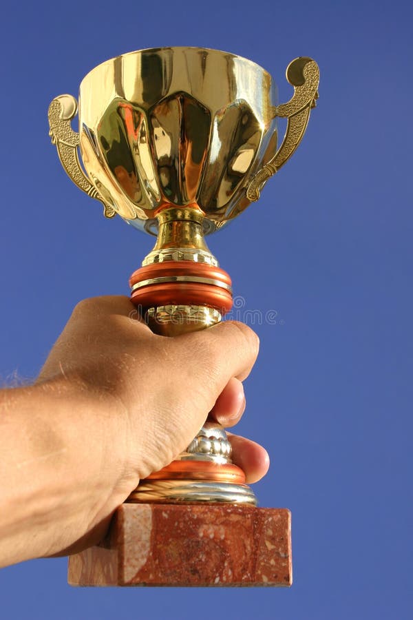 Mano, trofeo y cielo imagen de archivo libre de regalías Mano, trofeo y cielo imagen de archivo libre de regalías