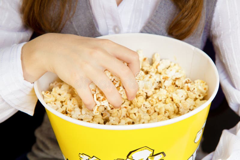Mano in una benna di popcorn fotografie stock libere da diritti Mano in una benna di popcorn fotografie stock libere da diritti