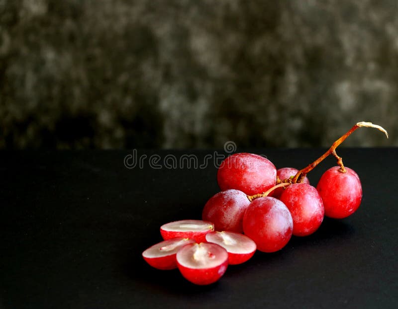 Manojo de uvas rosadas en un fondo negro fotos de archivo libres de regalías Manojo de uvas rosadas en un fondo negro fotos de archivo libres de regalías