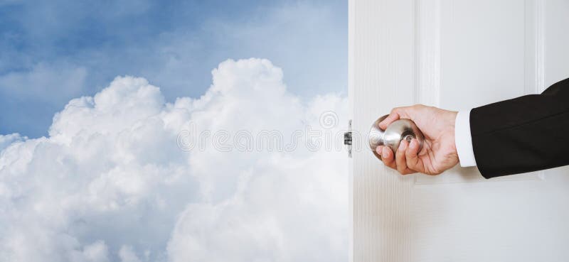 Manopola di porta della tenuta della mano dell'uomo d'affari, apertura al cielo e nuvole, con lo spazio della copia, concetto ast