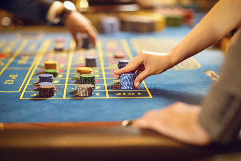 Manos con los microprocesadores en la tabla de la ruleta del póker que juega en un casino fotos de archivo Manos con los microprocesadores en la tabla de la ruleta del póker que juega en un casino fotos de archivo