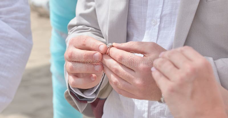 Manos de Holding de novia y del novio y anillos del cambio imagen de archivo Manos de Holding de novia y del novio y anillos del cambio imagen de archivo