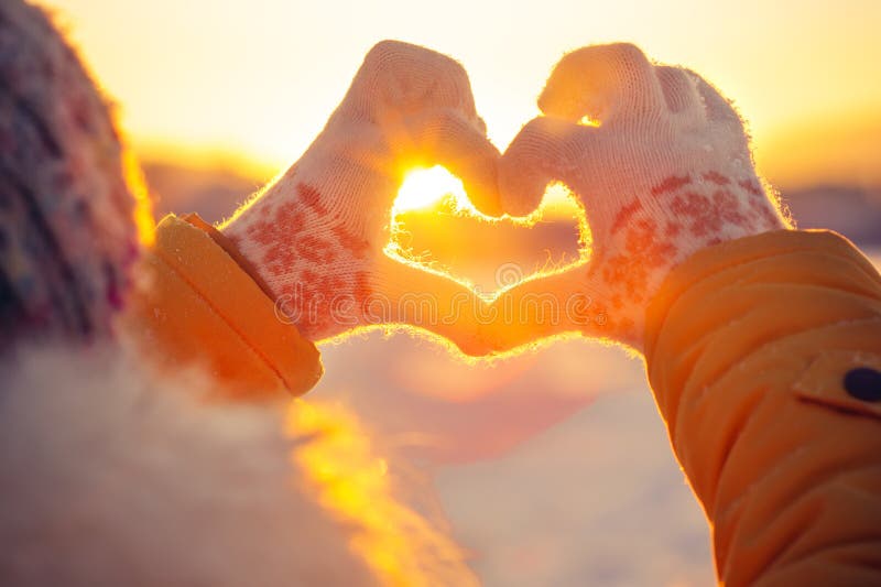 Manos de la mujer en el símbolo del corazón de los guantes del invierno formado imagen de archivo libre de regalías