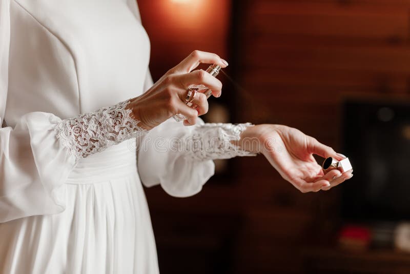 Manos de la novia que aplican el perfume en su muñeca, foco selectivo del primer fotografía de archivo libre de regalías Manos de la novia que aplican el perfume en su muñeca, foco selectivo del primer fotografía de archivo libre de regalías
