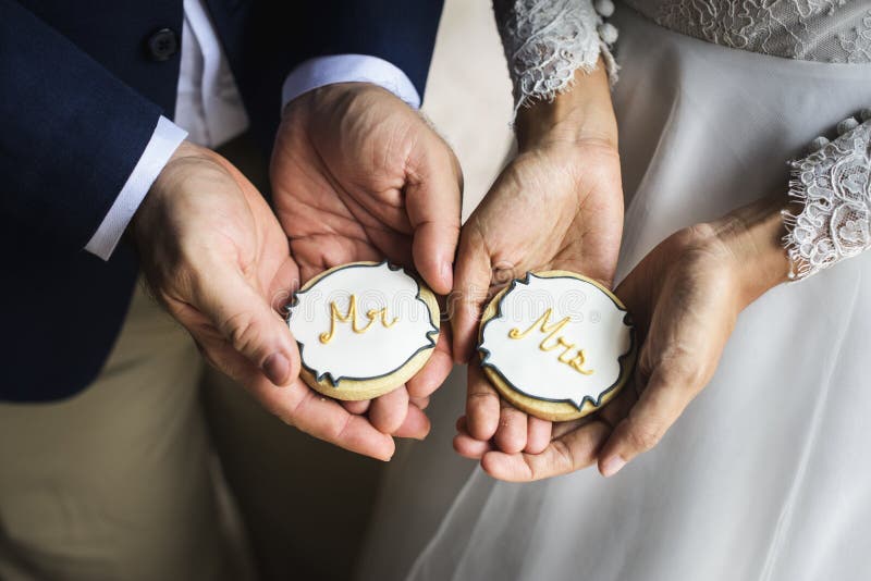 Manos de los pares del recién casado que celebran mostrar las galletas que se casan Celebratio fotografía de archivo libre de regalías Manos de los pares del recién casado que celebran mostrar las galletas que se casan Celebratio fotografía de archivo libre de regalías