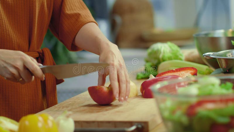 Manos de mujer cortando manzana roja en la cocina Ensalada de verduras para cocinar para amas de casa