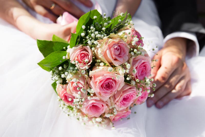 Manos de novia y del novio que sostienen el ramo rosado de las rosas fotos de archivo libres de regalías Manos de novia y del novio que sostienen el ramo rosado de las rosas fotos de archivo libres de regalías