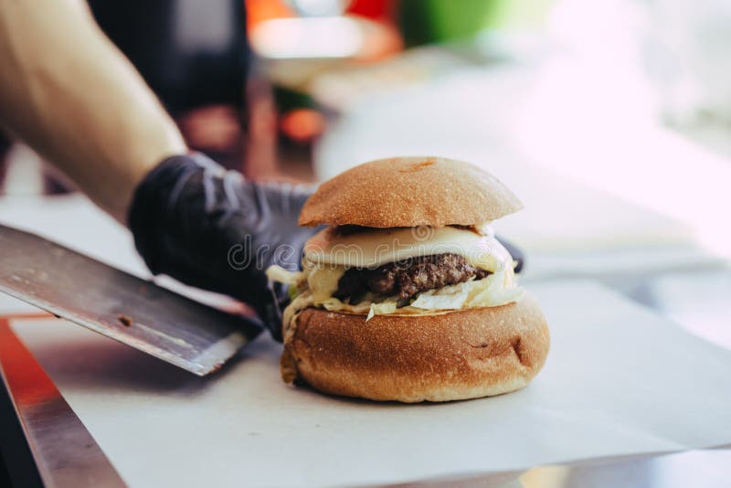 Manos del cocinero que preparan y que hacen la hamburguesa imagen de archivo libre de regalías Manos del cocinero que preparan y que hacen la hamburguesa imagen de archivo libre de regalías