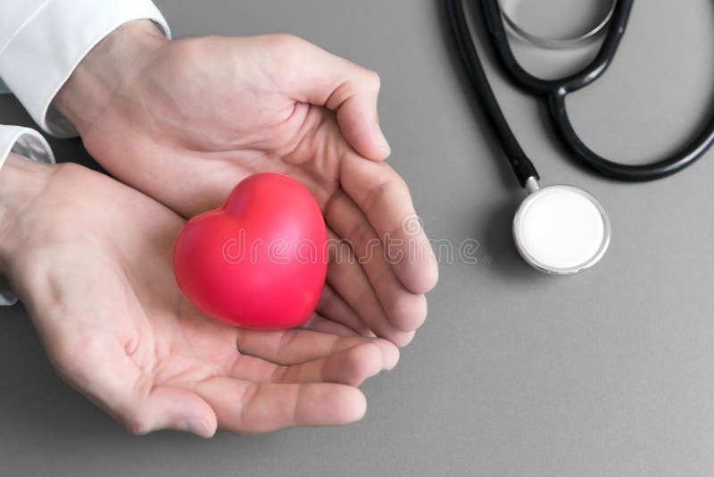 Manos del doctor que se sostienen y dar el coraz?n rojo del masaje al paciente para recuperarse de enfermedad Concepto del hospit