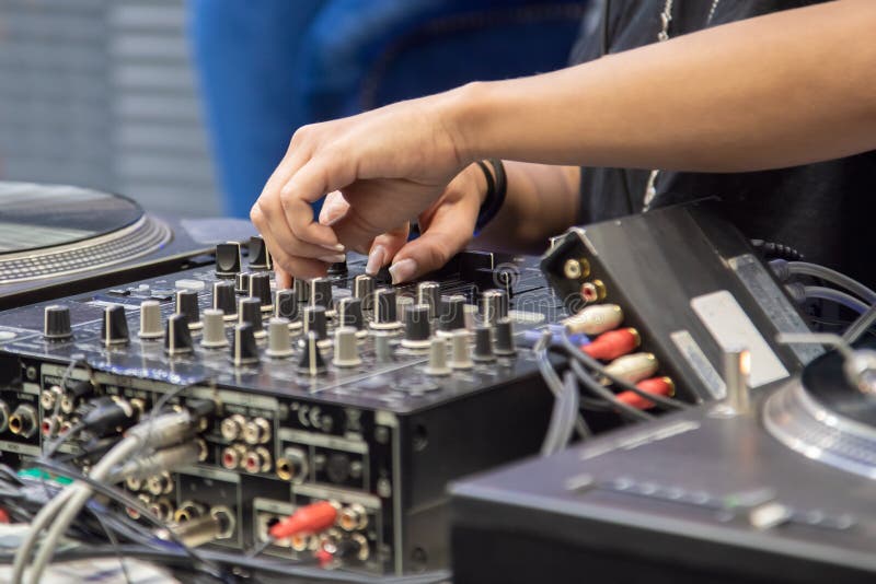 Manos femeninas que juegan el mezclador de DJ foto de archivo libre de regalías Manos femeninas que juegan el mezclador de DJ foto de archivo libre de regalías