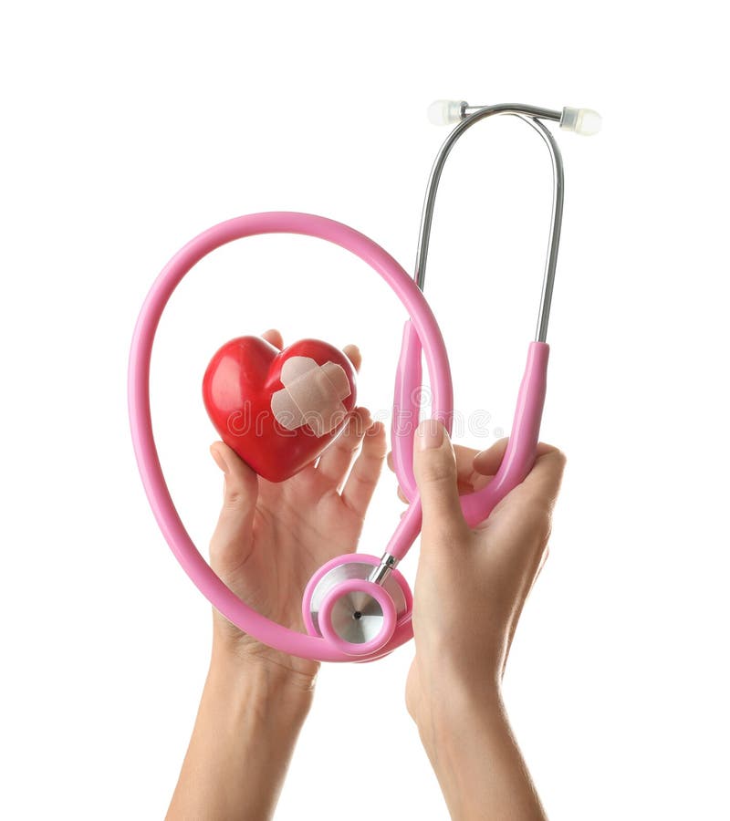 Manos femeninas que llevan a cabo el estetoscopio médico y el corazón rojo con yeso en el fondo blanco foto de archivo Manos femeninas que llevan a cabo el estetoscopio médico y el corazón rojo con yeso en el fondo blanco foto de archivo