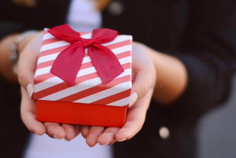 Manos femeninas que sostienen una caja de regalo, presente foto de archivo Manos femeninas que sostienen una caja de regalo, presente foto de archivo