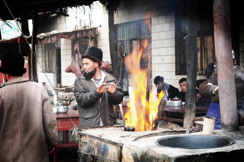 Manos que se calientan del hombre de Uyghur imagen de archivo Manos que se calientan del hombre de Uyghur imagen de archivo