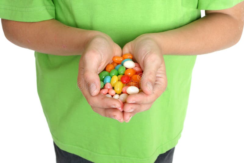 Child's hands holding a handful of lollies. Child's hands holding a handful of lollies.
