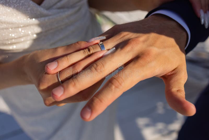 Mans Hand Putting a Wedding Ring on the Brides Finger. Stock Image