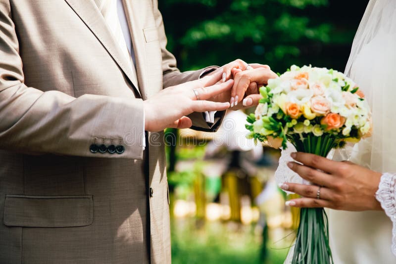 Mans Hand Putting a Wedding Ring on the Brides Stock Image Image of