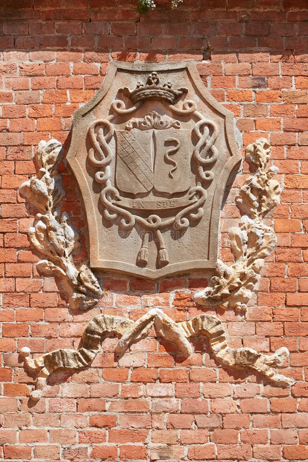 Manteau de château de Barolo des bras médiéval sur le mur de briques rouges en Italie images stock Manteau de château de Barolo des bras médiéval sur le mur de briques rouges en Italie images stock