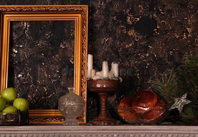 Mantelpiece with frame, apples, cakes, candlestick and pine branch