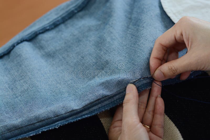 Manual Sewing Moment by Hands Inserting the Needle in Fabric Stock