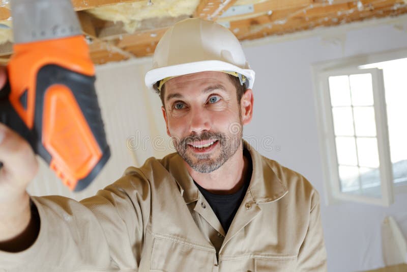 Manual Worker Drilling Ceiling with Drilling Machine Stock Photo