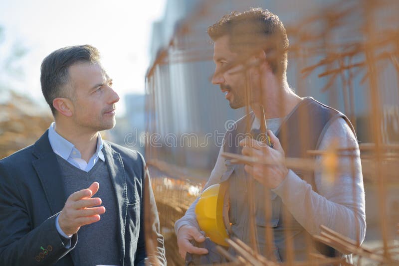 Manual worker talking to manager by rebars stock image Manual worker talking to manager by rebars stock image