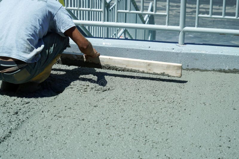 Manual Worker Working on Smooth Concrete on Driveway Stock Photo