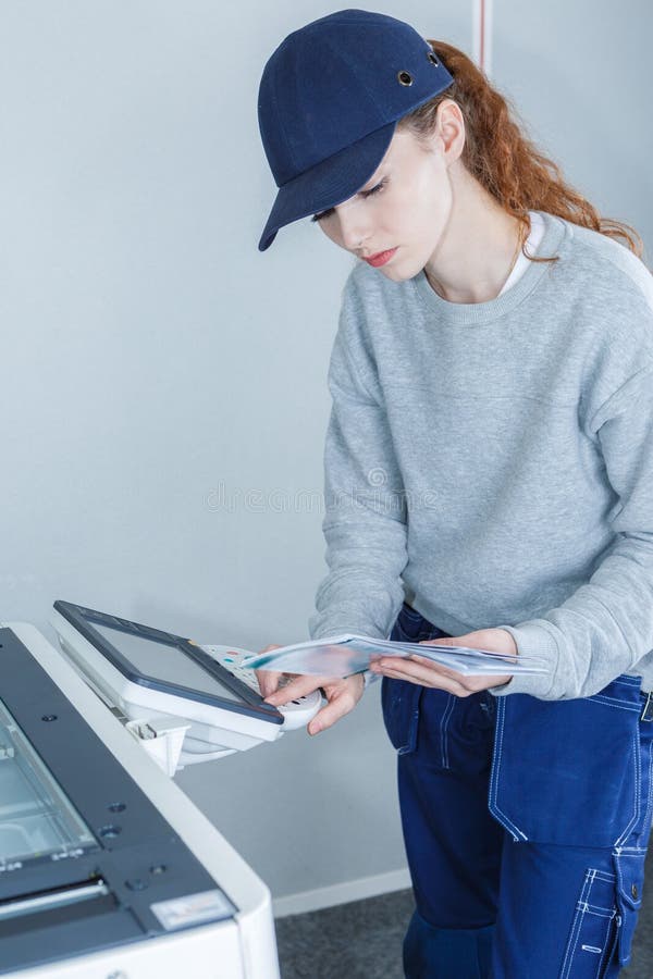 Manuale femminile della tenuta del tecnico e fotocopiatrice di programmazione fotografie stock libere da diritti Manuale femminile della tenuta del tecnico e fotocopiatrice di programmazione fotografie stock libere da diritti