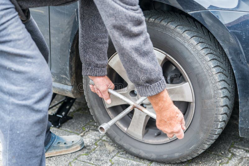 Manually tire change with four-way socket wrench