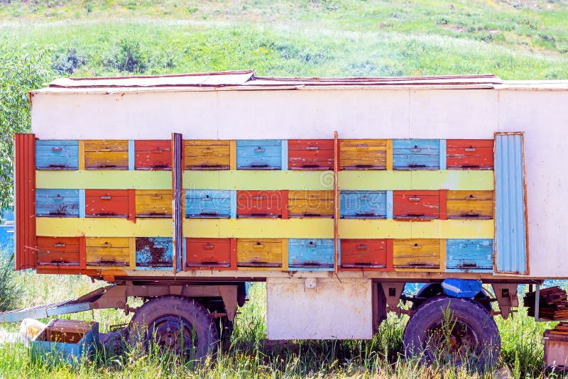 Many bee hives in the car truck (beekeeping wagon) on the country farm on the sunny summer day. stock photos Many bee hives in the car truck (beekeeping wagon) on the country farm on the sunny summer day. stock photos