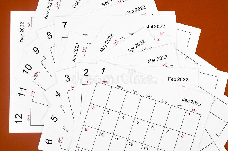 Many Blank Monthly 2022 Calendar Sheets on Red Background Stock Image