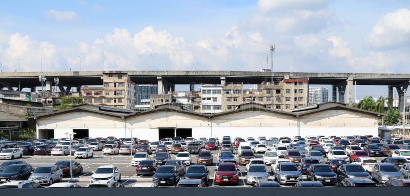 Many cars are parked at the outdoor parking lot with garage building and taller building, Expressway and blue sky. stock images Many cars are parked at the outdoor parking lot with garage building and taller building, Expressway and blue sky. stock images