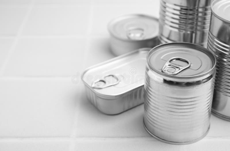 Many Closed Tin Cans on White Tiled Table, Closeup. Space for Text Stock Photo Image of group