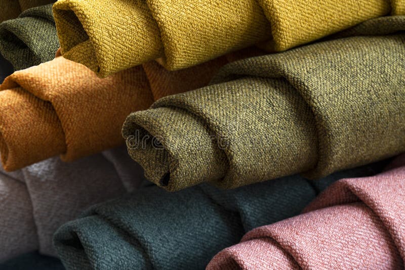 Many colorful rolls of fabric on a plain background royalty free stock images