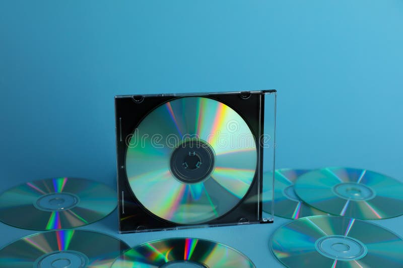 Many compact discs on light blue background royalty free stock image