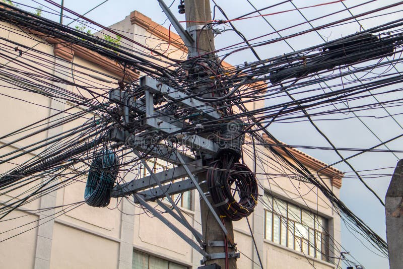 Many electrical wires on pillar. Asian urban electric supply. Industrial electrification pole with wire mess. stock photos Many electrical wires on pillar. Asian urban electric supply. Industrial electrification pole with wire mess. stock photos