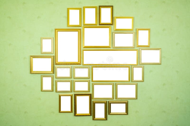 Many empty golden wooden frames with copy space on green wall. royalty free stock photography