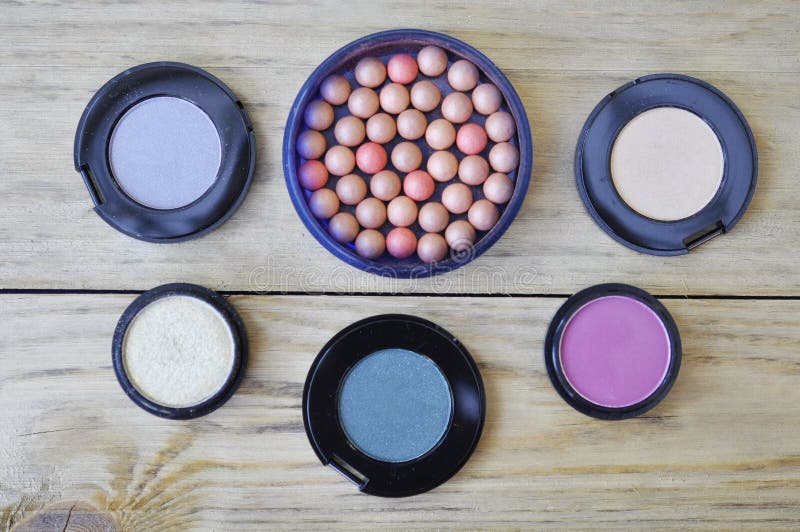 Many Eye Shadows And Rouge On Wood Table