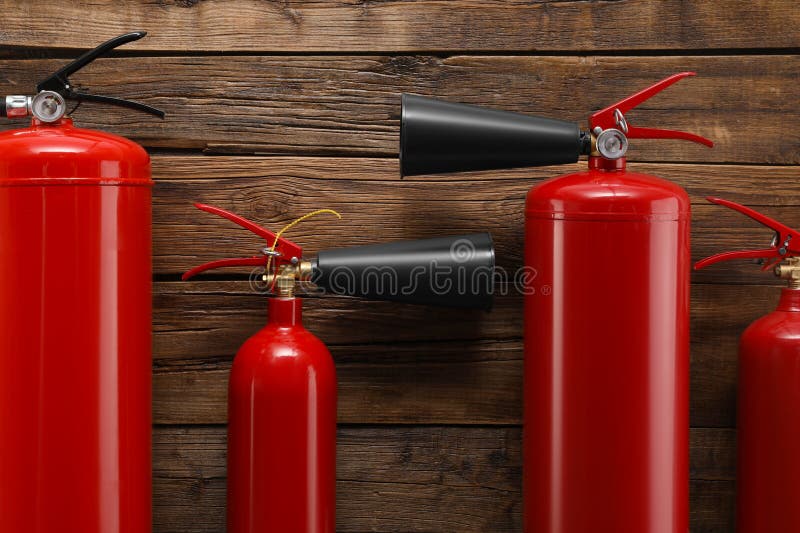 Many fire extinguishers on wooden background, flat lay royalty free stock image