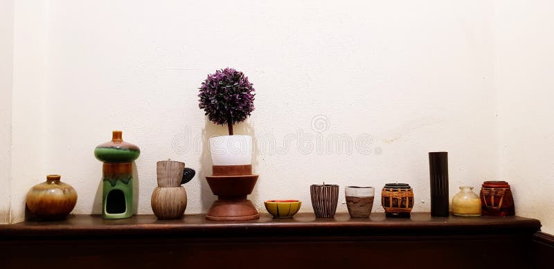 Many flower pot, earthenware or ceramic putting on wooden shelf or cabinet for decoration house with white wall background. Beautiful object for decorated stock images Many flower pot, earthenware or ceramic putting on wooden shelf or cabinet for decoration house with white wall background. Beautiful object for decorated stock images