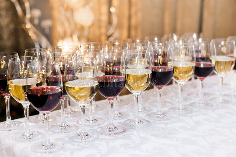 Many Glasses with White and Red Wine on Buffet Table Stock Photo