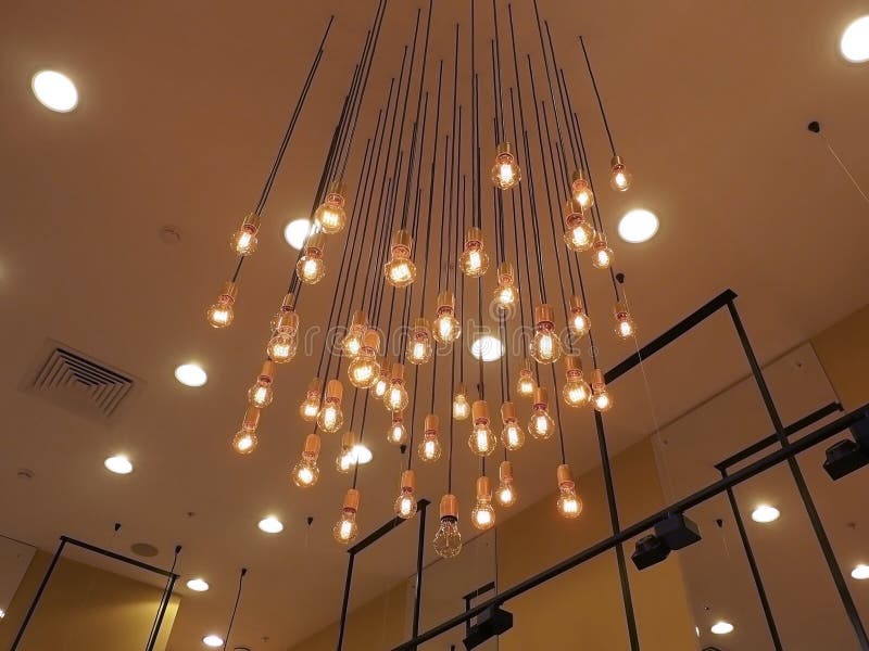 Many Bright Glowing Bulbs Hang from the Ceiling. Decorative Lighting